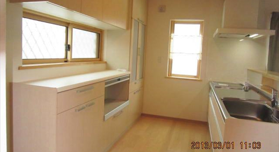 【キッチン】ベージュ色の木目のキッチンはナチュラルな色合い。大型の食器収納も家電収納付きで使いやすさ抜群。